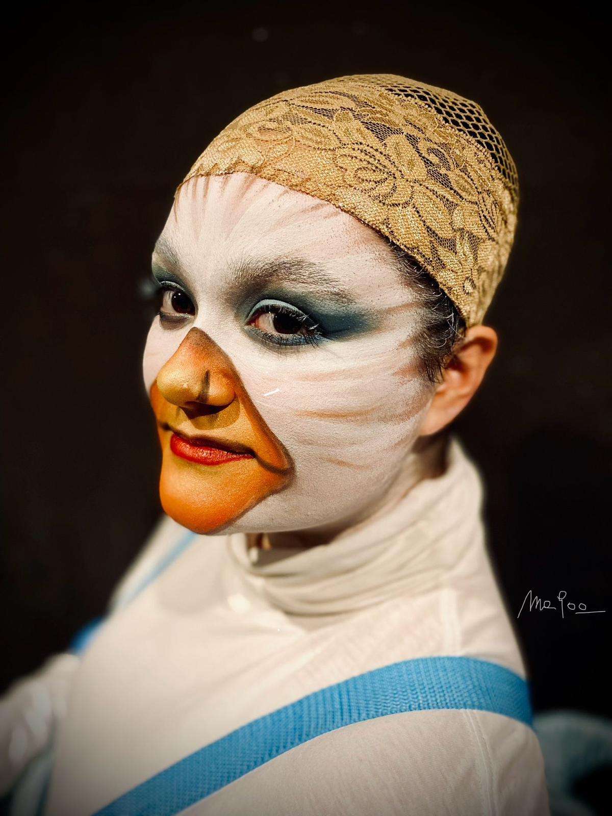 Trucco teatrale da personaggio con becco arancione dipinto e cuffia di pizzo